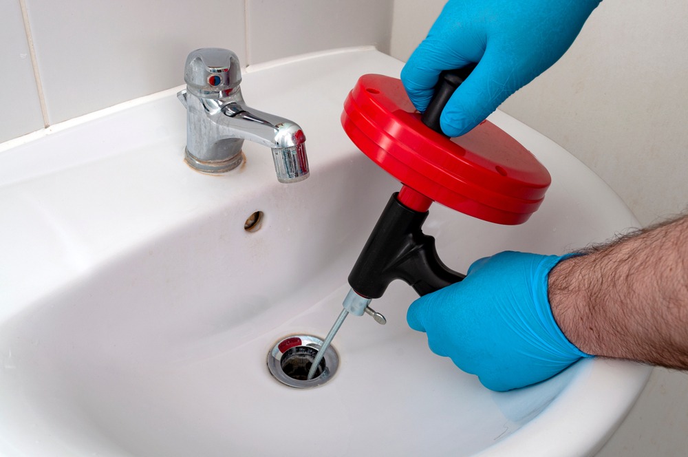 https://www.plumbingbyjake.com/wp-content/uploads/2023/06/plumber-using-auger-to-snake-a-drain.jpg